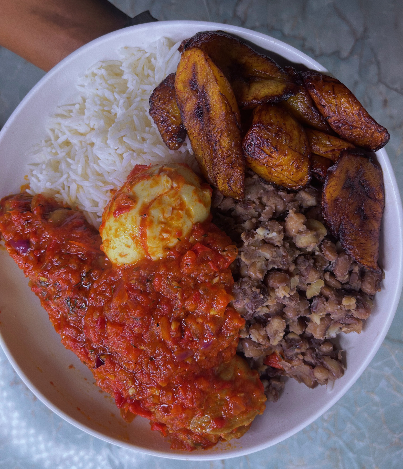 Plated Nigerian boiled rice served with rich tomato stew